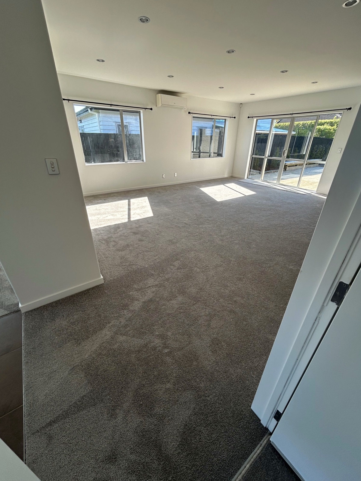 Fresh grey carpet installed through an open-plan living area